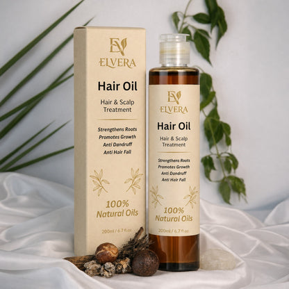 Elvera Hair Oil bottle and packaging on a white fabric background with green leaves.